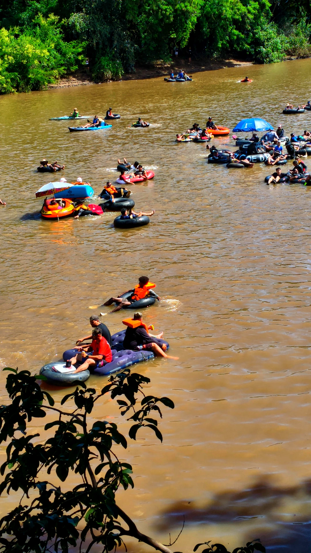 Pessoas boiando em câmaras de ar durante a descida de boia no Rio Piracicaba