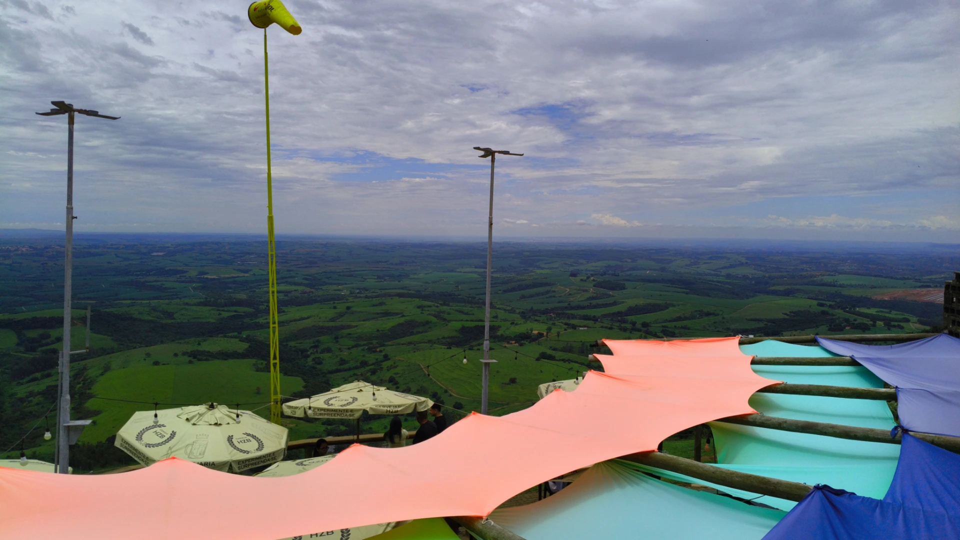 Vista do Bar da Rampa na Serra de São Pedro, com toldos coloridos, biruta de vento e panorama do vale